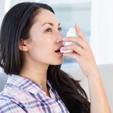 Junge Frau mit weißem Inhalator