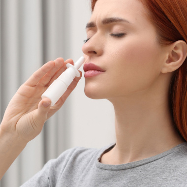 Nærbillede af en mand, der bruger en næsespray.