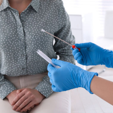 Female nurse showing female patient a swab test for STIs.