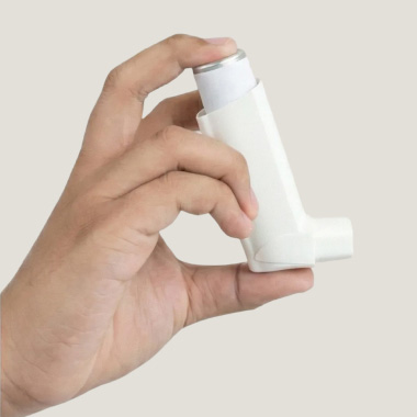 Close up of a hand holding an inhaler.