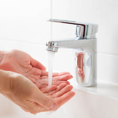 Soapy hands being washed in the sink
