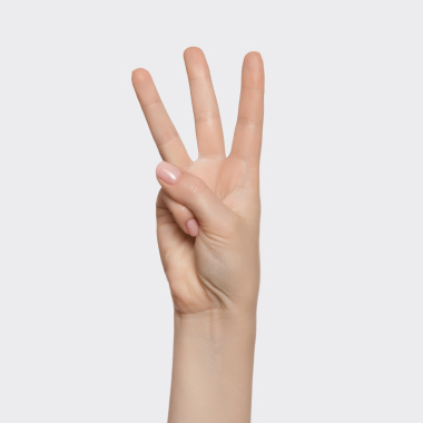 A woman on a couch smiling with a mug in her hands.