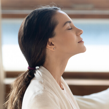 A young woman breathing deeply with her eyes closed
