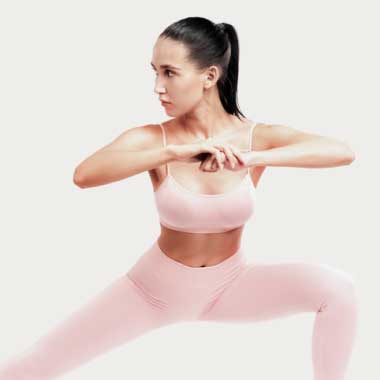 A woman in pink gym clothes stretching