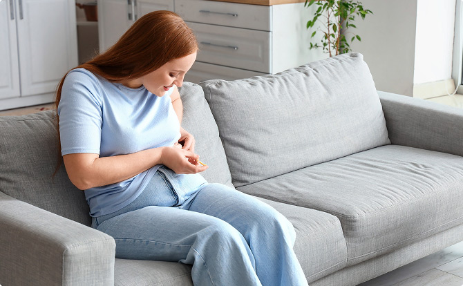 Woman injecting a weight loss pen into her abdomen
