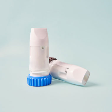 Gros plan de deux inhalateurs à poudre sèche sans marque sur fond bleu.