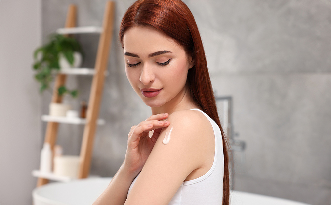 Jeune femme appliquant une crème sur son coude
