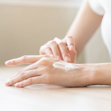 Femme appliquant une crème sur le dos de sa main