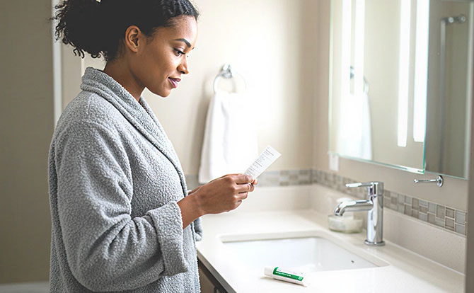 Femme se préparant à appliquer une crème de traitement dans une salle de bains