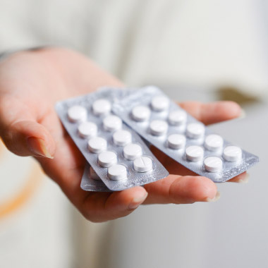 Mão a tocar no mostrador de um relógio analógico