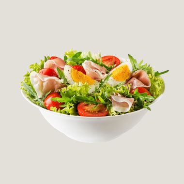 Plano aproximado das mãos de uma mulher a tomar comprimidos ao lado de um prato de comida.