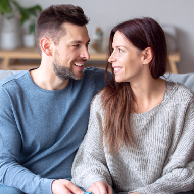 Um casal sorridente a olhar um para o outro.