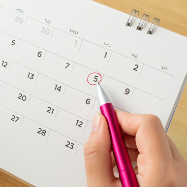 En närbild av en kalender där den 5:e är inringad med röd penna.