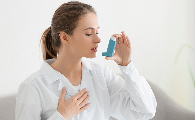 En man med astmasymtom som använder en inhalator.